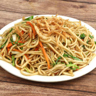 Veg Hakka Noodles a popular oriental dish made with noodles and vegetables, served over a rustic wooden background, selective focus