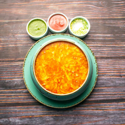 Hot and Sour Soup with sauces served in broth isolated on wooden table top view of bangladeshi and thai food